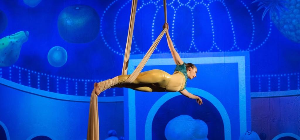 A woman hangs horizontally from silks