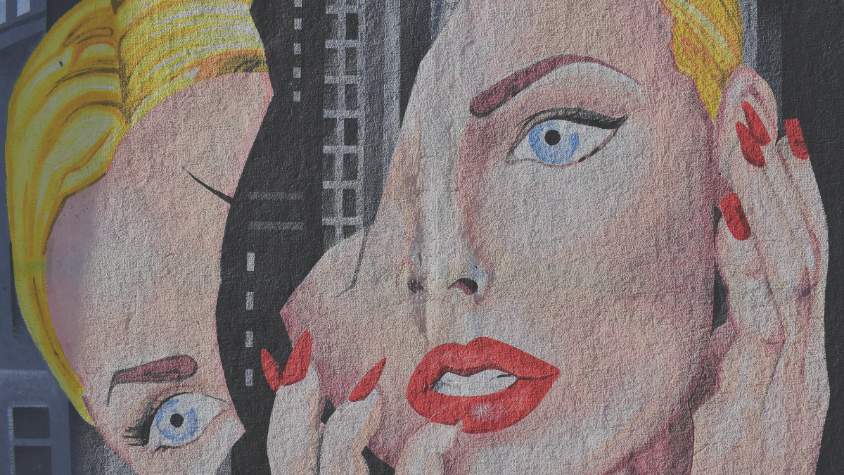 Street art of a pop art-style woman's face with the top left half cracking off